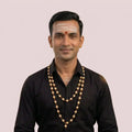 A double-strand beaded necklace  features alternating round white wood beads with small gold metal cap with copper wire